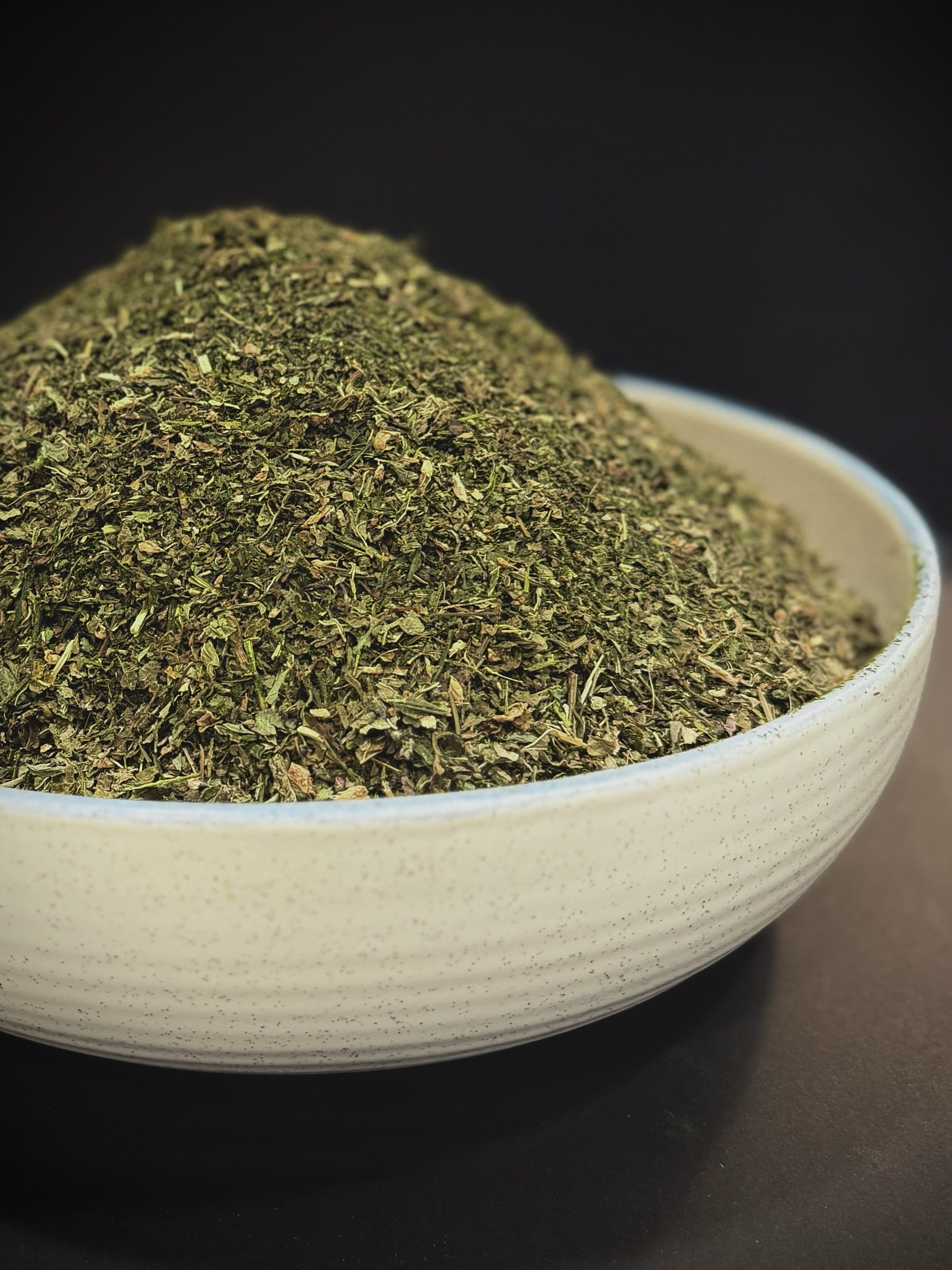 Sovereign Standard tea heaped in a ceramic bowl, with fine leaf and stem textures in natural light